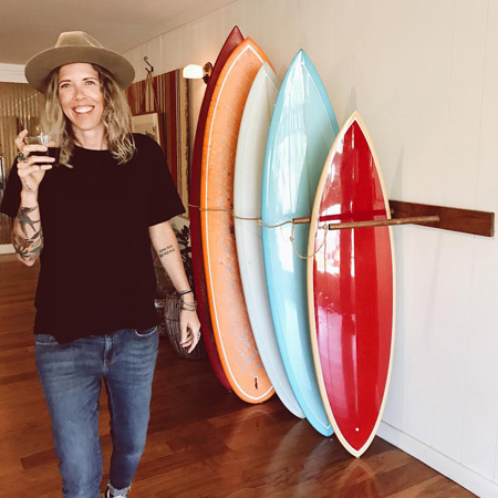 Woman standing next to some surfboards