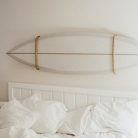 Surfboard over a bed at Laguna Beach House